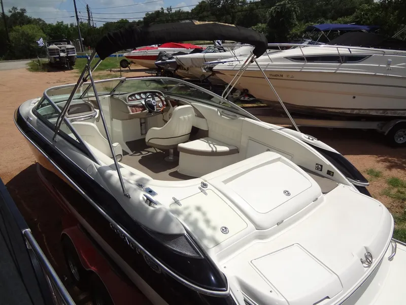 Slide: The Image of 2004 Cobalt 240 boat with open deck and seating, parked outdoors. - 5