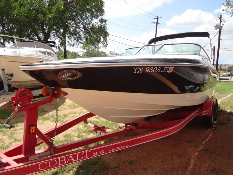 Slide: The Image of 2004 Cobalt 240 boat on red trailer, parked outdoors. - 6