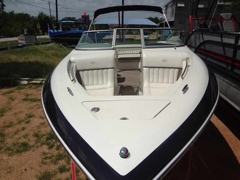Slide: The Image of 2004 Cobalt 240 boat with white interior, parked on a trailer outdoors. - 9