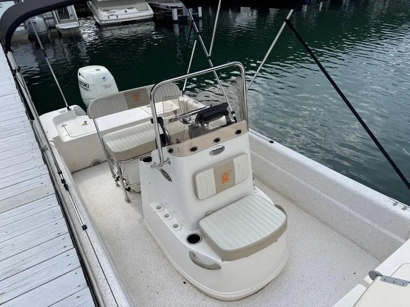 Slide: The Image of 2019 Carolina Skiff 18 JVX CC boat docked, featuring center console and seating. - 2