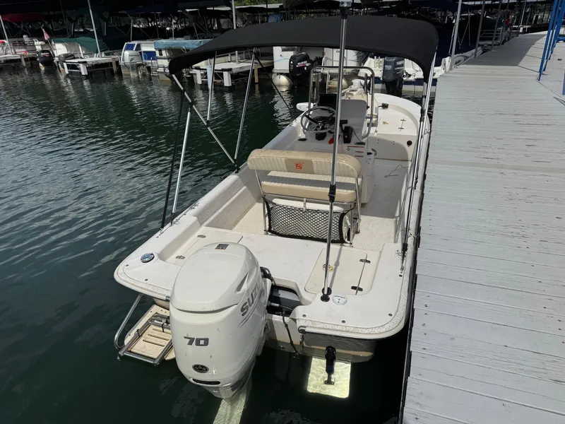 Slide: The Image of 2019 Carolina Skiff 18 JVX CC boat docked, featuring a Suzuki 70 outboard motor. - 3