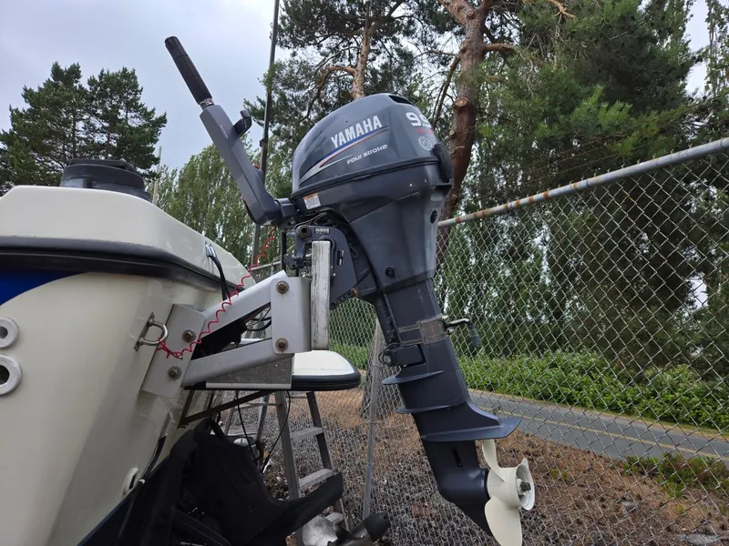 Slide: The Image of 1995 SeaSport 2400 Explorer with Yamaha outboard motor, parked near a chain-link fence. - 14