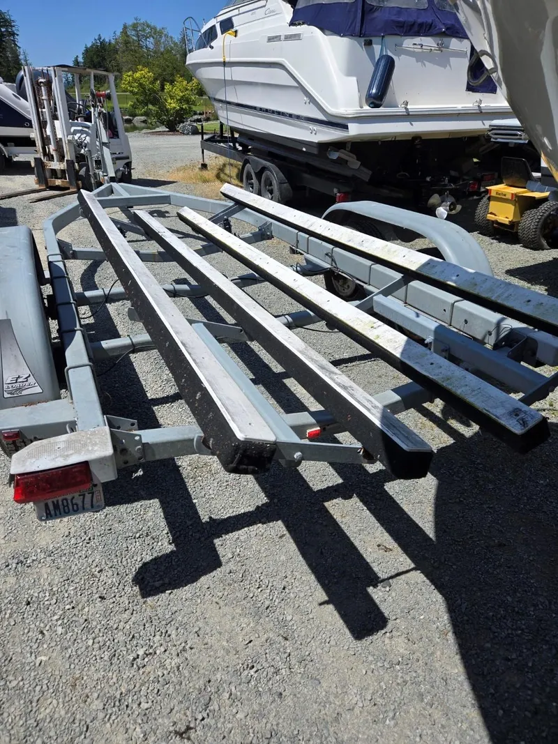 Slide: The Image of Boat trailer for 1995 SeaSport 2400 Explorer, parked outdoors on gravel. - 19