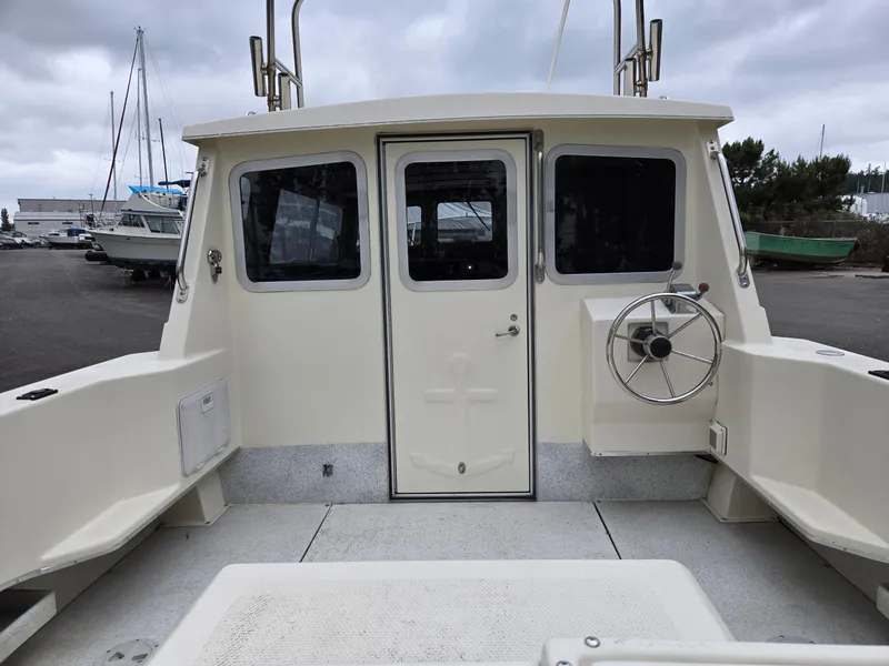 Slide: The Image of 1995 SeaSport 2400 Explorer boat with enclosed cabin and steering wheel, docked under cloudy skies. - 21