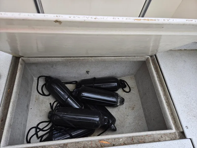 Slide: The Image of Storage compartment on a 1995 SeaSport 2400 Explorer boat with black fenders inside. - 23