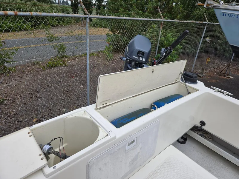 Slide: The Image of 1995 SeaSport 2400 Explorer boat with open storage compartments and outboard motor. - 24