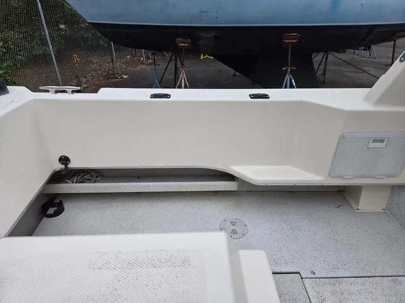 Slide: The Image of 1995 SeaSport 2400 Explorer boat deck, featuring clean white surfaces and storage compartments. - 25