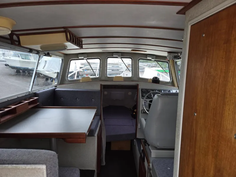 Slide: The Image of Interior of a 1995 SeaSport 2400 Explorer boat, featuring seating and navigation area. - 32