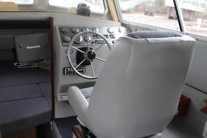 Slide: The Image of 1995 SeaSport 2400 Explorer boat interior with steering wheel and captain's chair. - 35