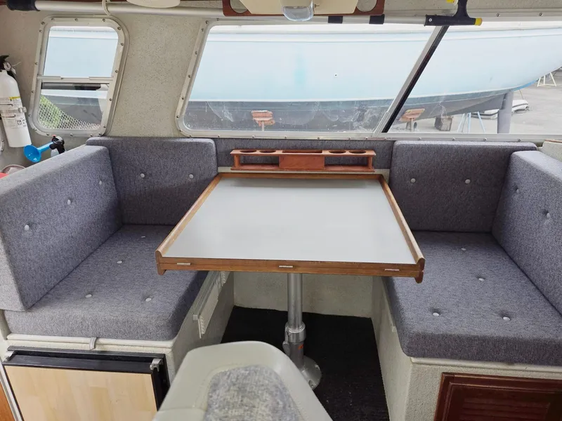 Slide: The Image of Interior of a 1995 SeaSport 2400 Explorer boat with gray seating and a central table. - 44