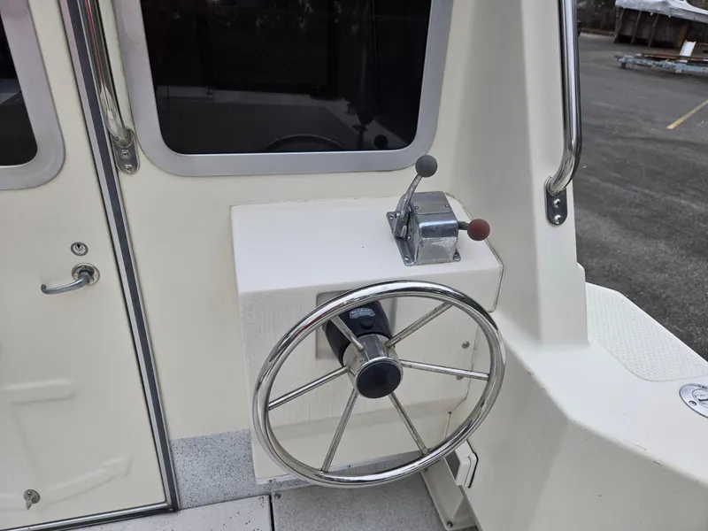 Slide: The Image of Steering wheel and controls of a 1995 SeaSport 2400 Explorer boat. - 7