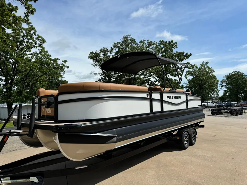 Slide: The Image of 2025 Premier 250 Sunsation Rear Social pontoon boat on trailer, parked outdoors. - 5