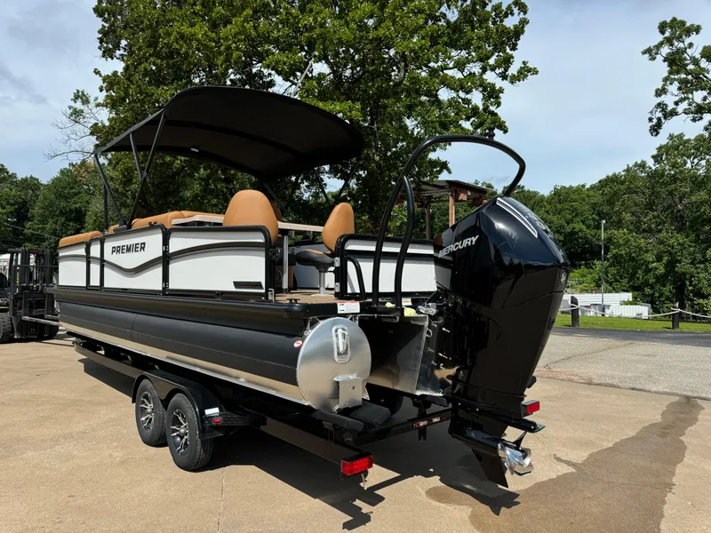 Slide: The Image of 2025 Premier 250 Sunsation Rear Social pontoon boat on trailer, parked outdoors. - 6