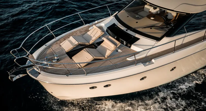 Slide: The Image of 2017 Beneteau Monte Carlo MC6 yacht with sun loungers on deck, cruising on open water. - 8