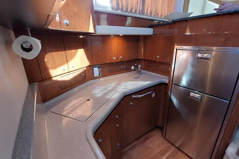 Slide: The Image of Luxurious 2004 Sea Ray 390 Motor Yacht kitchen with wood cabinetry and stainless steel appliances. - 15