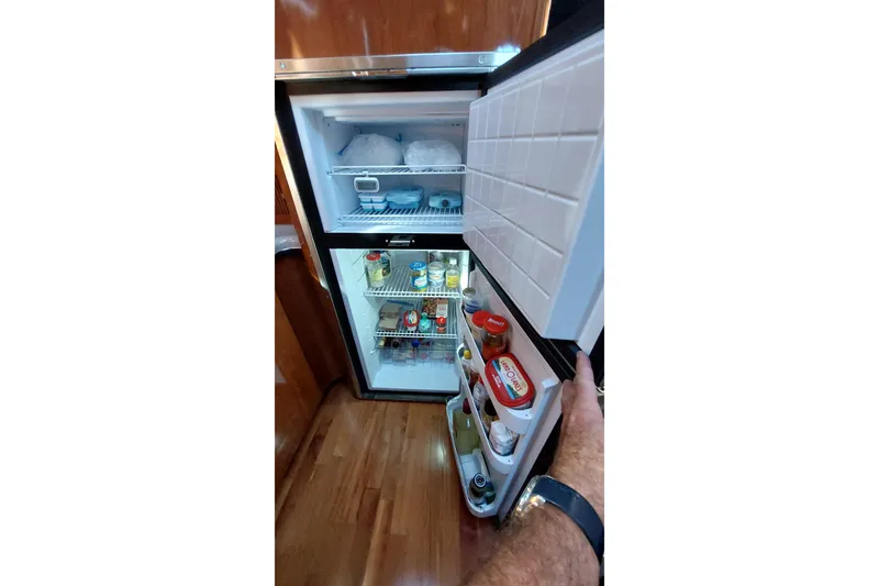 Slide: The Image of Open refrigerator inside 2004 Sea Ray 390 Motor Yacht, stocked with various food items. - 16