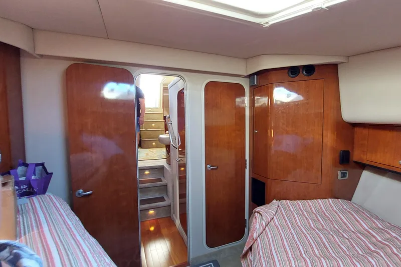 Slide: The Image of Interior of 2004 Sea Ray 390 Motor Yacht with wood paneling and striped bedding. - 22