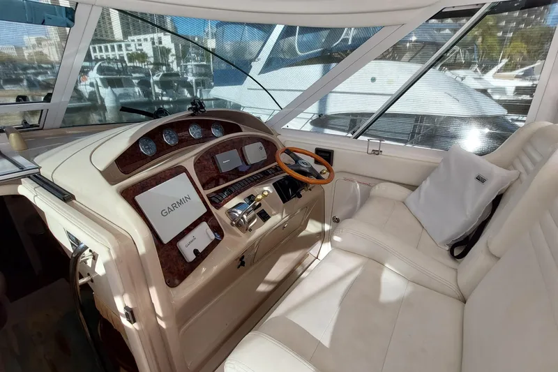 Slide: The Image of 2004 Sea Ray 390 Motor Yacht helm with Garmin navigation, luxurious seating, and modern controls. - 26