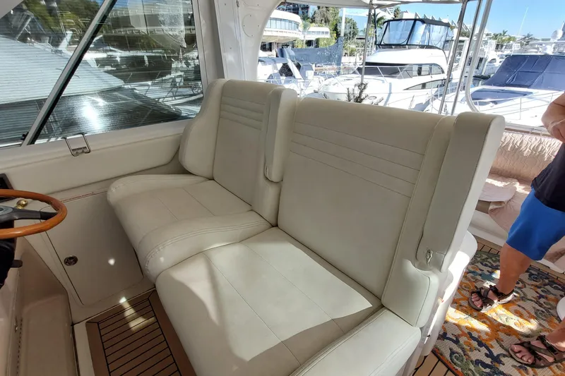 Slide: The Image of 2004 Sea Ray 390 Motor Yacht interior with white seating and wooden accents. - 27