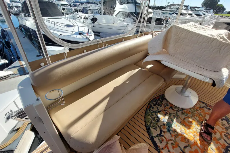 Slide: The Image of 2004 Sea Ray 390 Motor Yacht interior with beige seating and marina view. - 28