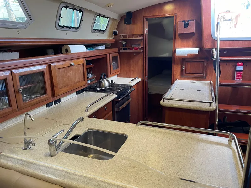 Slide: The Image of Interior of 2010 Hunter 49 Aft Cockpit yacht kitchen with wooden cabinetry and modern appliances. - 11
