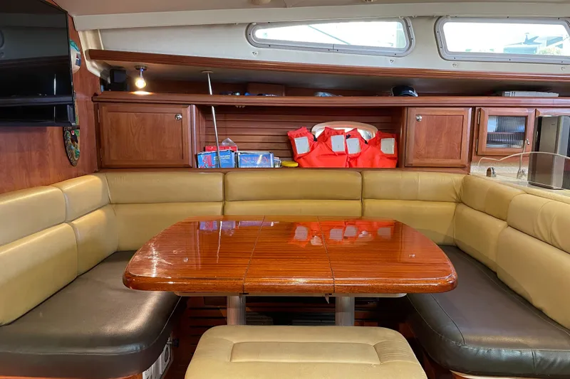 Slide: The Image of Interior of 2010 Hunter 49 Aft Cockpit yacht with wooden table and cushioned seating. - 15