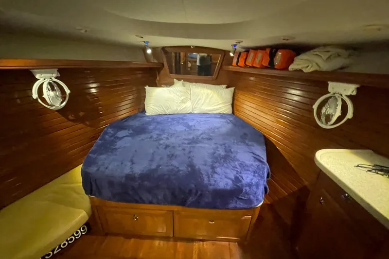 Slide: The Image of Cozy cabin interior of 2010 Hunter 49 Aft Cockpit with wooden finish and blue bedding. - 17