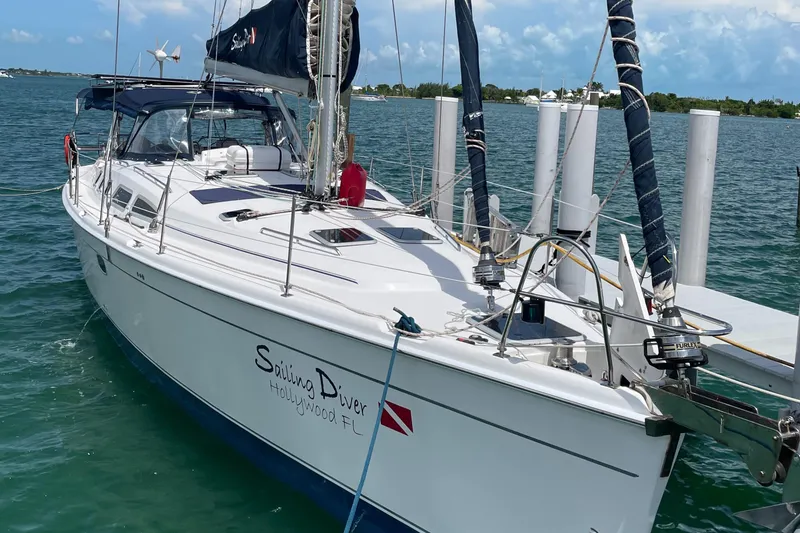 Slide: The Image of 2010 Hunter 49 Aft Cockpit sailboat docked in clear blue water. - 3