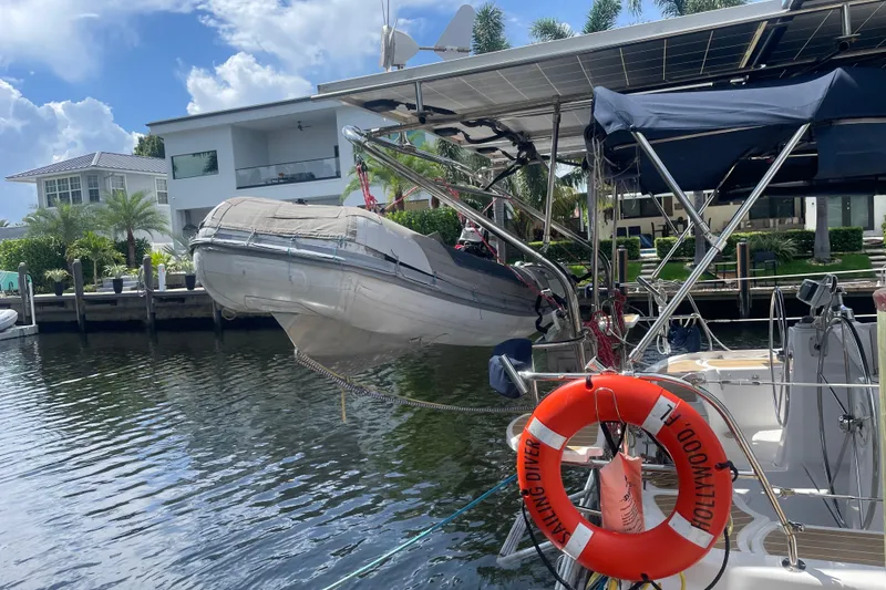 Slide: The Image of Hunter 49 Aft Cockpit 2010 yacht with dinghy and solar panels docked by waterfront homes. - 39