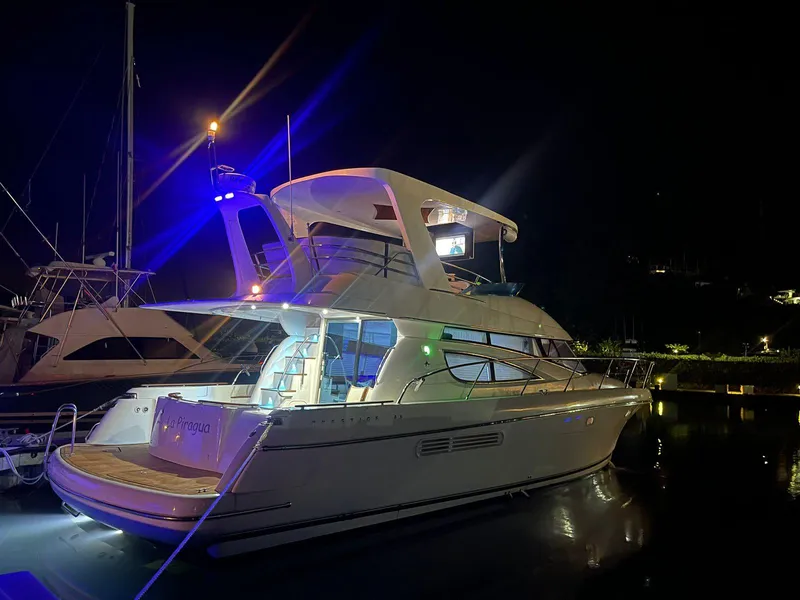 Slide: The Image of Luxury 2006 Prestige 46 yacht illuminated at night in a marina setting. - 20