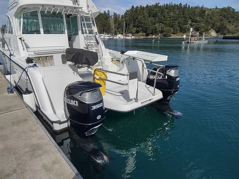 Slide: The Image of 2005 Glacier Bay 3490 Ocean Runner with dual Suzuki outboard motors docked in a marina. - 32