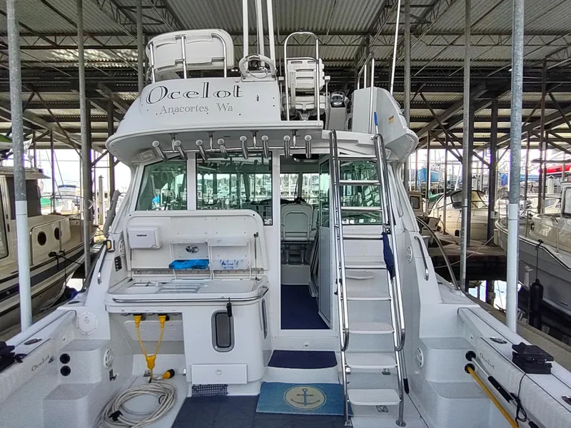 Slide: The Image of 2005 Glacier Bay 3490 Ocean Runner boat docked in a marina, rear view. - 34