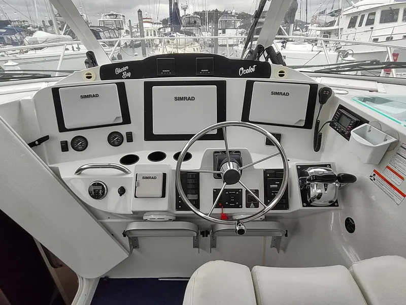 Slide: The Image of Helm of 2005 Glacier Bay 3490 Ocean Runner with Simrad navigation systems and steering wheel. - 42