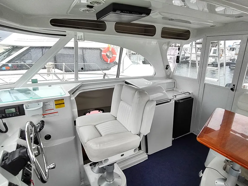 Slide: The Image of Interior of 2005 Glacier Bay 3490 Ocean Runner boat with white seating and wooden table. - 44