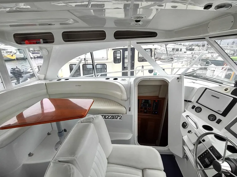 Slide: The Image of Interior of 2005 Glacier Bay 3490 Ocean Runner boat with white seating and control panel. - 46