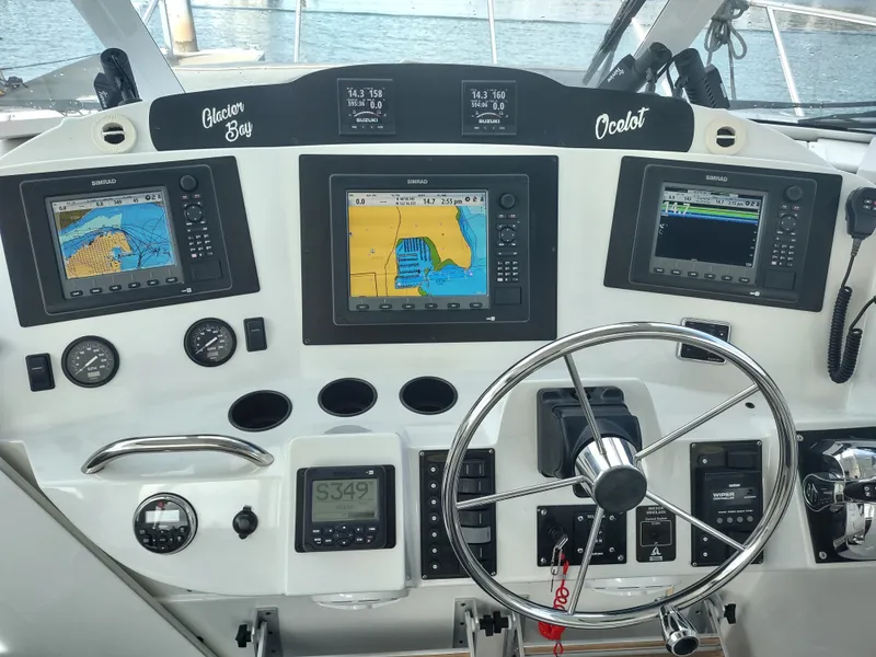 Slide: The Image of 2005 Glacier Bay 3490 Ocean Runner dashboard with navigation screens and steering wheel. - 48