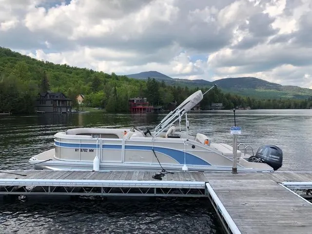 Slide: The Image of 2019 Bennington SX 22 SSBXP pontoon boat docked on a scenic lake. - 0