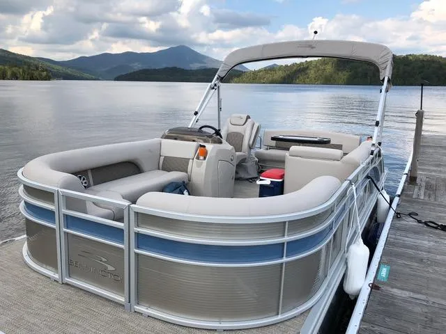 Slide: The Image of 2019 Bennington SX 22 SSBXP pontoon boat docked on a serene lake with mountain views. - 1