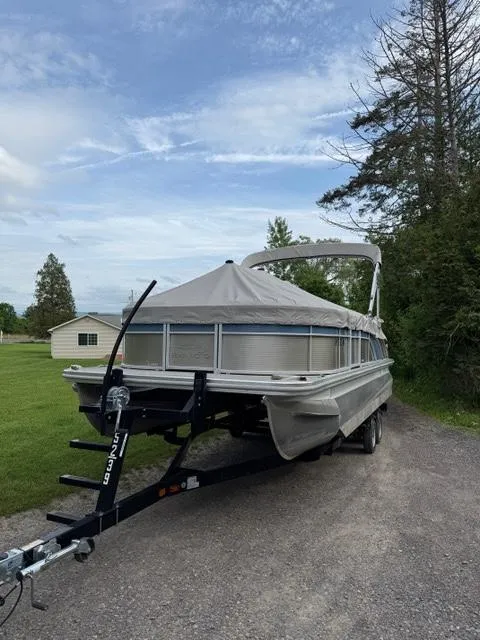Slide: The Image of 2018 Bennington SX 22 SSBXP pontoon boat on trailer, covered, parked outdoors. - 14
