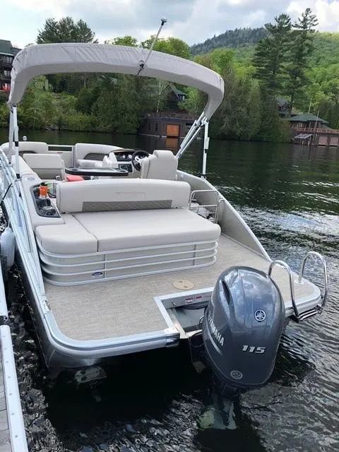 Slide: The Image of 2019 Bennington SX 22 SSBXP pontoon boat docked on a scenic lake. - 2