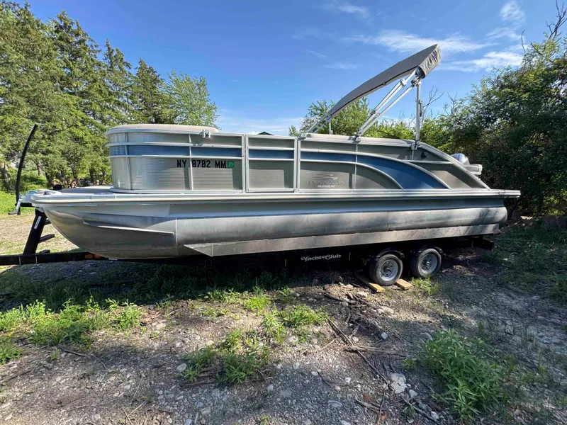 Slide: The Image of 2018 Bennington SX 22 SSBXP pontoon boat on trailer, surrounded by trees and grass. - 26
