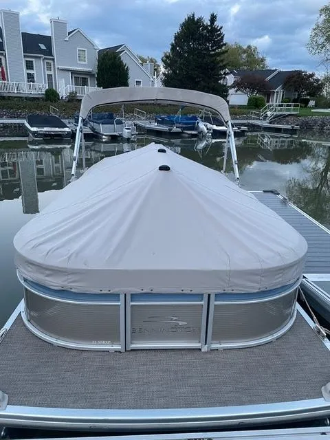 Slide: The Image of 2019 Bennington SX 22 SSBXP pontoon boat docked with cover, residential background. - 4