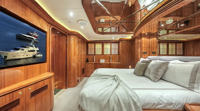 Slide: The Image of Luxurious 2007 Horizon 95 yacht bedroom with wood paneling and modern amenities. - 27