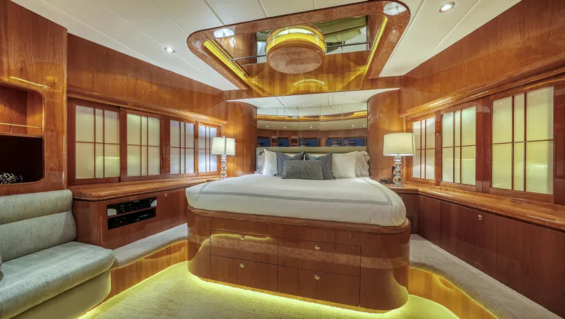 Slide: The Image of Luxurious bedroom interior on a 2007 Horizon 95 yacht, featuring elegant wood paneling and ambient lighting. - 31