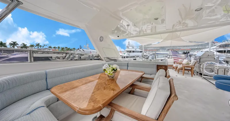 Slide: The Image of Luxurious 2007 Horizon 95 yacht deck with elegant seating and dining area, under a clear blue sky. - 42