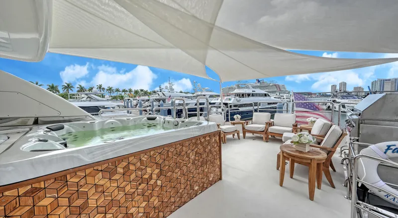 Slide: The Image of Luxurious Horizon 95 yacht deck with jacuzzi, seating, and marina view under a sunny sky. - 46