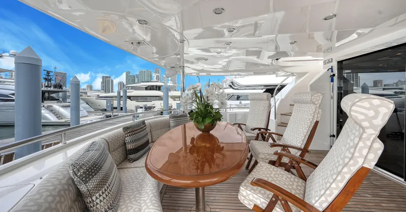Slide: The Image of Luxurious 2007 Horizon 95 yacht deck with elegant seating and table, docked at marina. - 48