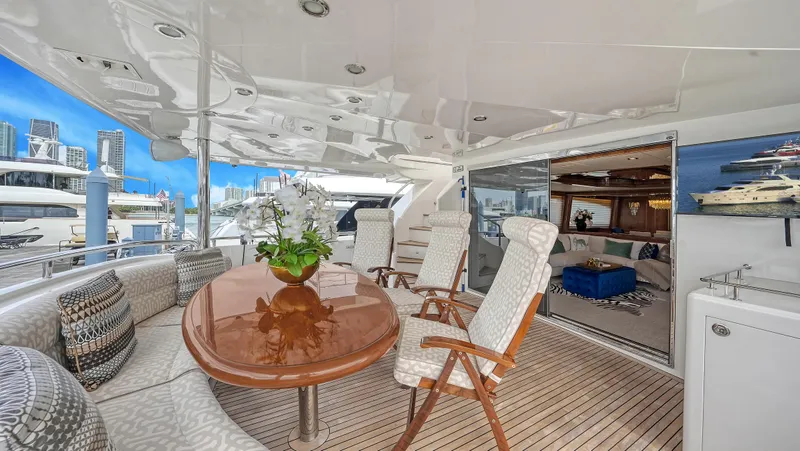 Slide: The Image of Luxurious Horizon 95 yacht deck with elegant seating, wooden table, and marina view, 2007 model. - 9
