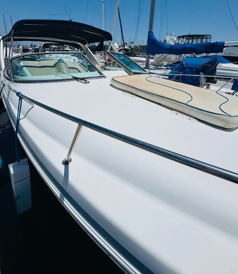 Slide: The Image of 2000 Chris-Craft 308 Express Cruiser docked at marina, featuring sleek white design. - 12