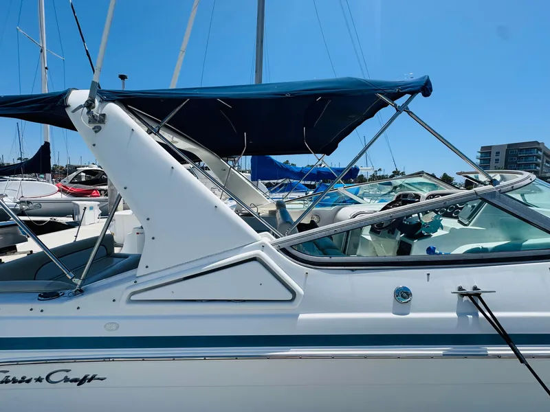 Slide: The Image of 2000 Chris-Craft 308 Express Cruiser docked with blue canopy under clear sky. - 16